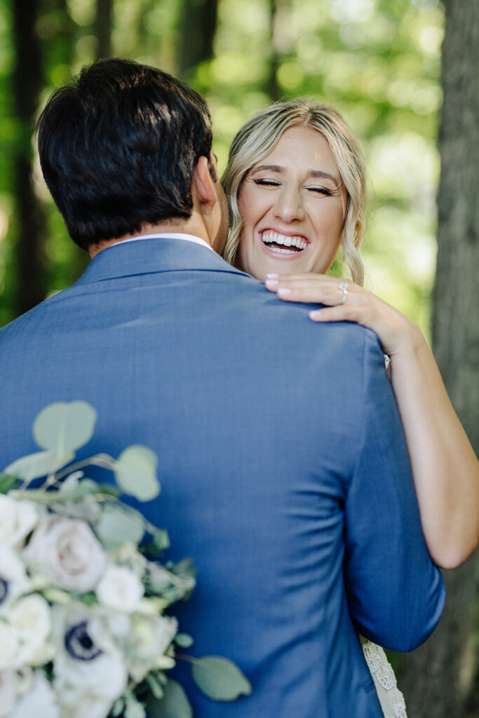 Wedding Photography and Videography Packages. Bride candidly smile as groom hugs her.