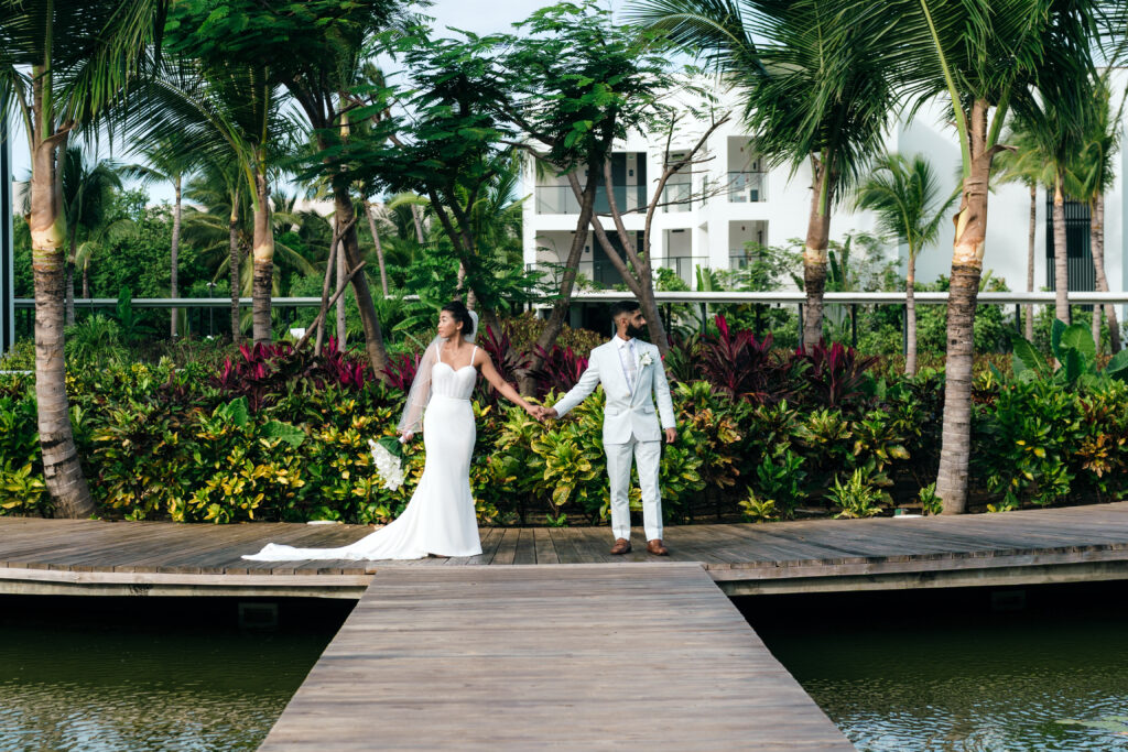 Couple holding hands in front of garden at resort, taken by For Fearless Hearts